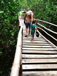 Rear view of shirtless man walking on stairs