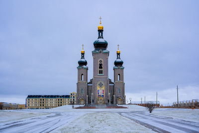 Buildings by sea against clear sky
