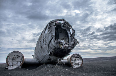 Abandoned airplane on black sand