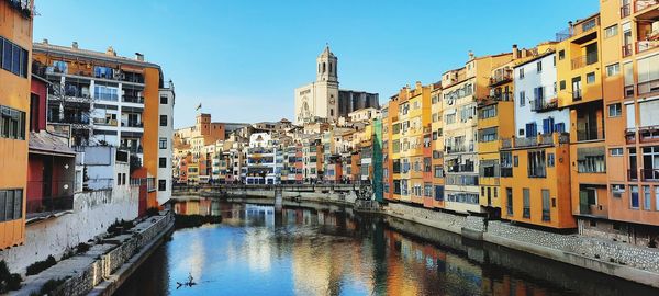 Canal amidst buildings against sky in city