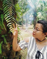 Young woman with palm tree on field