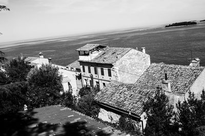 High angle view of buildings by sea against sky
