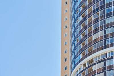 Low angle view of modern building against clear blue sky