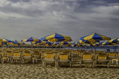 Chairs on beach against sky