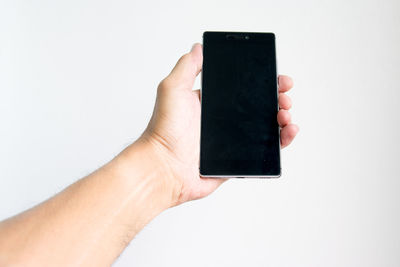 Midsection of person holding smart phone against white background