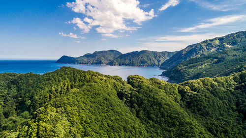 Scenic view of sea and mountains against sky