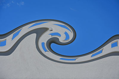 Mural of wave against blue sky