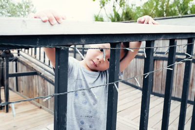 Portrait of boy looking through decorated railing