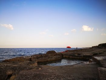 Scenic view of rocks on beach against sky