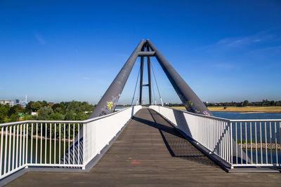 View of footbridge against clear blue sky