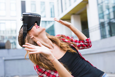 Midsection of woman standing with umbrella in city