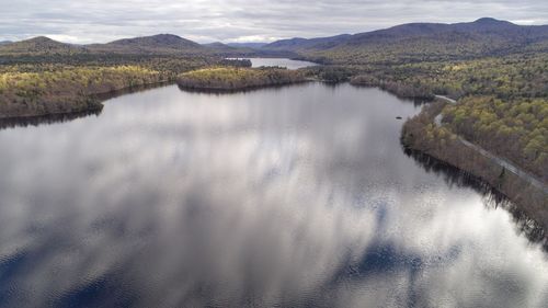 Scenic view of river and mountains against sky