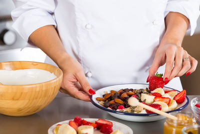 Midsection of chef preparing food in commercial kitchen