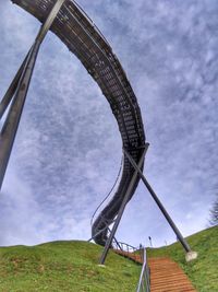 Low angle view of metallic structure on field against sky