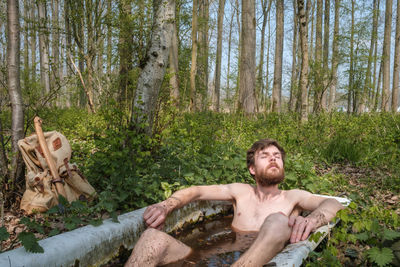 Portrait of young man relaxing in forest