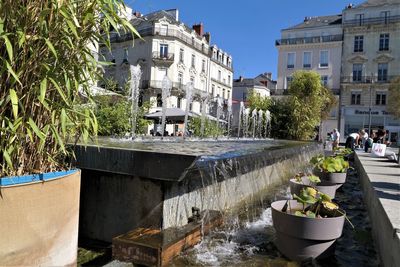 Fountain against buildings in city