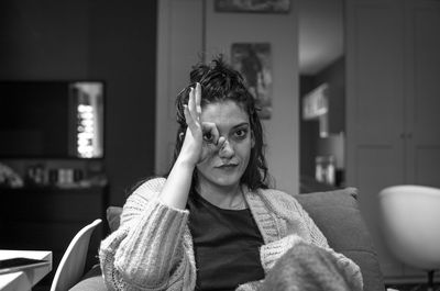 Portrait of young woman sitting on sofa at home