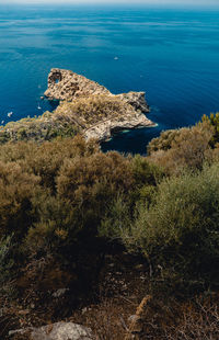 High angle view of rocks by sea against sky