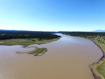 Scenic view of river against clear blue sky