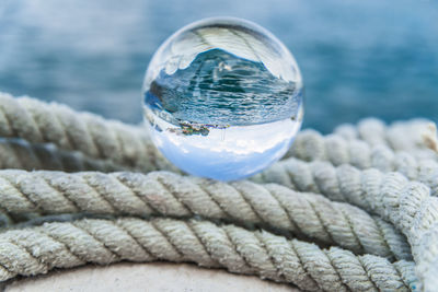 Close-up of crystal ball on rope at harbor