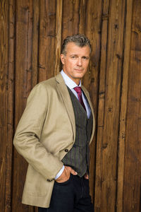 Portrait of smiling man standing on wood