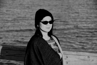 Portrait of man wearing sunglasses standing against sea