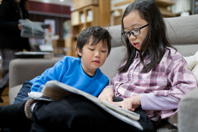 Mother and daughter sitting on book