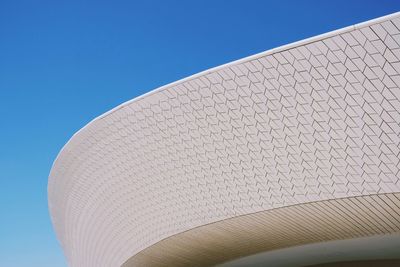 Low angle view of modern building against blue sky