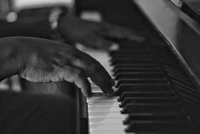 Close-up of hand playing piano