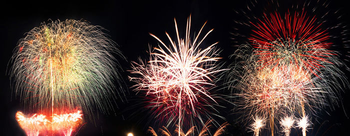 Low angle view of firework display at night