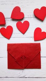 Red heart shape and envelope on table