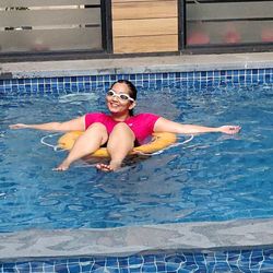 Portrait of a smiling young woman swimming in pool