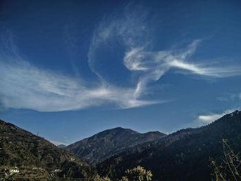 Scenic view of mountains against blue sky