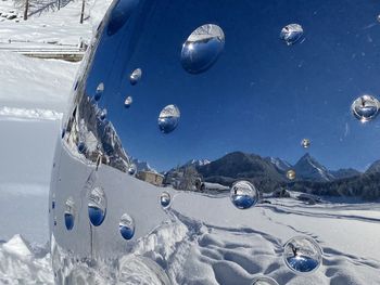 Panoramic view of snow covered land against blue sky