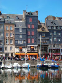 Boats in canal by buildings in city