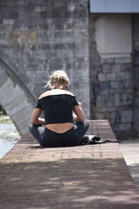 Rear view of woman sitting outdoors