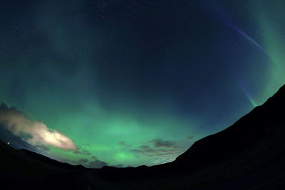 Low angle view of silhouette mountain against sky at night