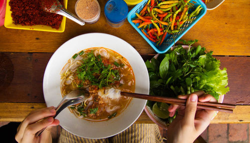 Cropped hands having food at table