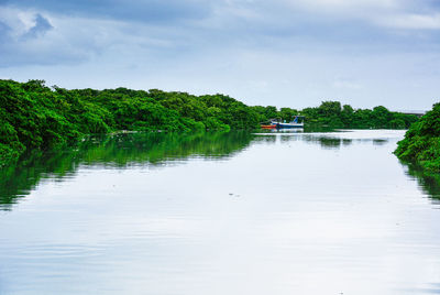 Scenic view of river against cloudy sky 