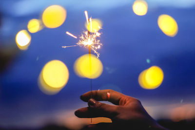 Blurred motion of person hand holding sparkler at night