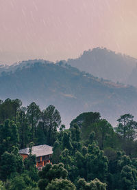 Scenic view of trees and mountains against sky