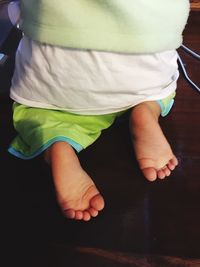 Low section of toddler boy on table