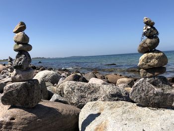 Stack of rocks on shore against clear sky