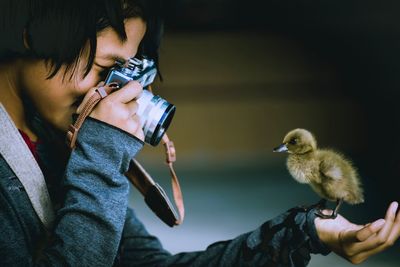 Midsection of man photographing with bird