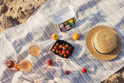 Rose wine, peaches and strawberries on the beach towel. beautiful summer picnic near the sea.