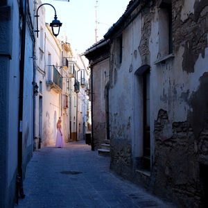 Woman walking along built structures