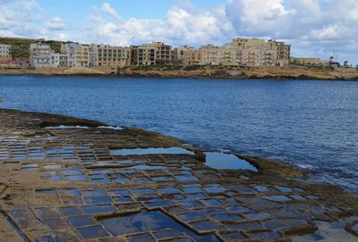 View of city by sea against sky