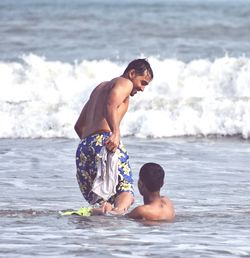 Full length of shirtless boy in sea