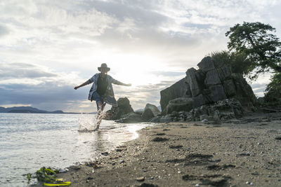 Teenage girl running barefoot through water at clayton beach