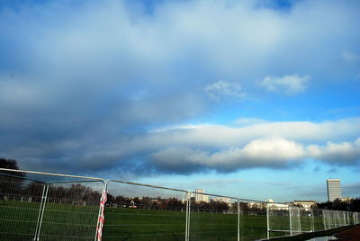 Fence against cloudy sky